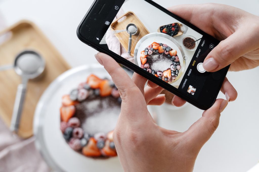 aplicativos de receita - imagem ilustrativa de pessoa tirando foto de um doce com o celular