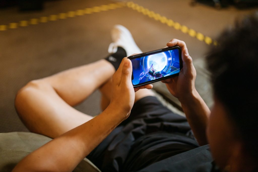 jogos de estratégia e habilidades - imagem ilustrativa de pessoa sentada jogando no celular